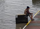 Mu sedí vedle silnice zatopené bleskovými povodnmi (18. ervence 2017)