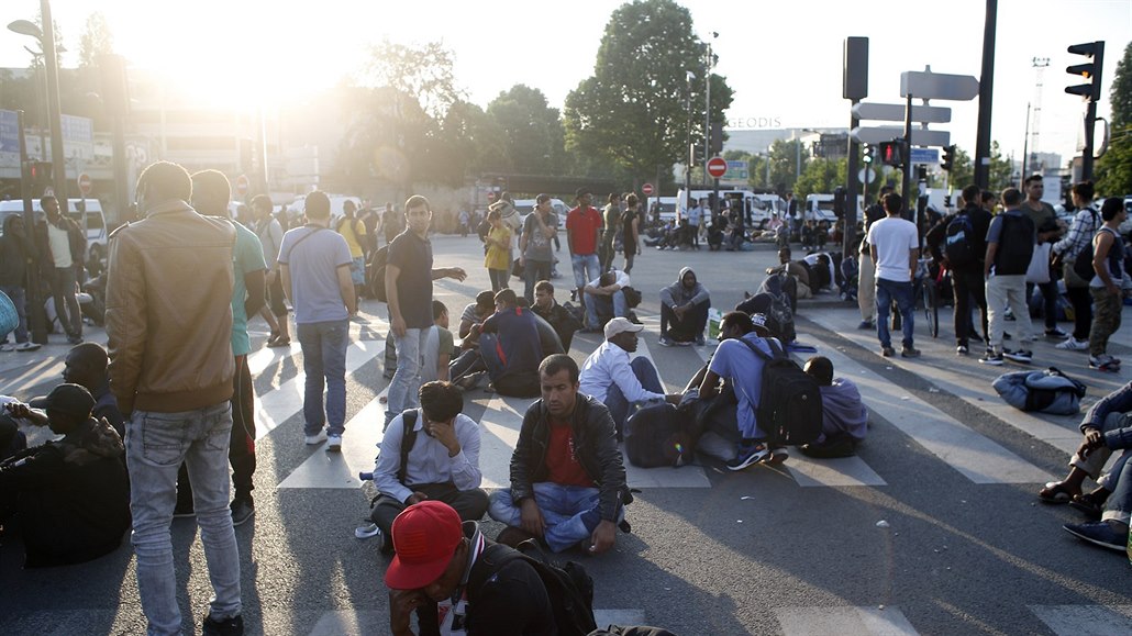 Migranti v Paříži čekají, až je francouzské úřady evakuují z improvizovaného...