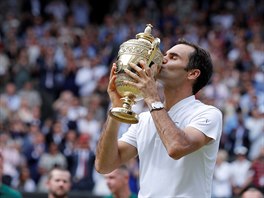 AMPION. Roger Federer lb trofej pro vtze slavnho Wimbledonu.