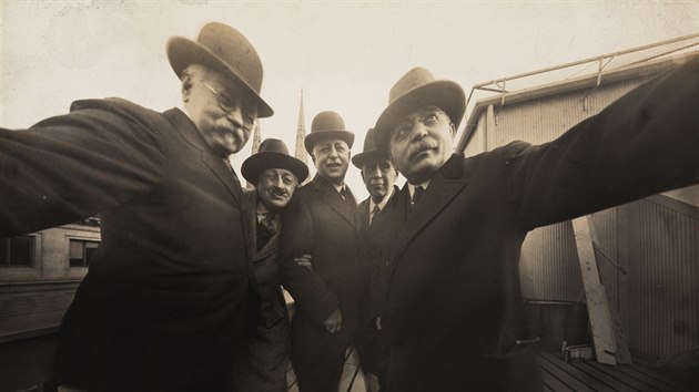 Group self-portrait of five photographers on the roof of Colonel Marceau's photography studio, New York, December 1920. Pictured are, from left, Joseph ('Uncle Joe') Byron (fore, left hand on camera), Pirie MacDonald (second left, in hat), Colonel Marceau and Pop Core (both hidden, and Joseph ('Uncle Joe') Byron (fore, left hand on camera), Pirie MacDonald (second left, in hat), Colonel Marceau and Pop Core (both hidden, and Ben Falk. Byron and Falk each hold a side of the camera.