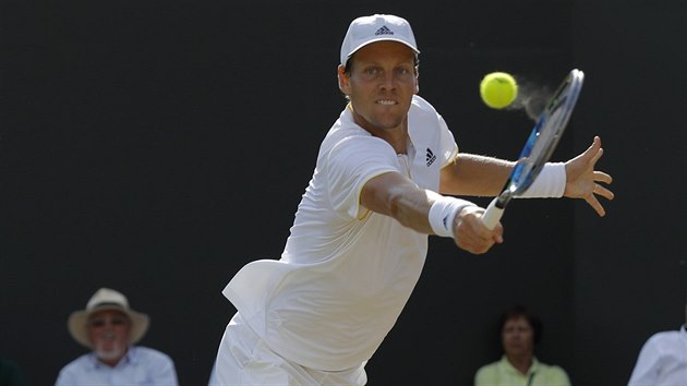 Tom Berdych se natahuje po bekhendovm deru v osmifinle Wimbledonu.