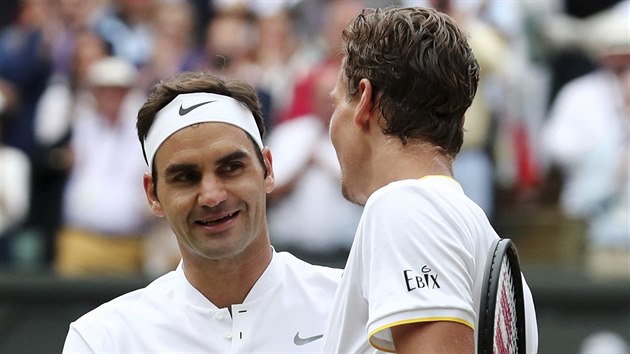 Gratulace. Roger Federer ze vcarska pijm gratulace od Tom Berdycha z eska po semifinle Wimbledonu.
