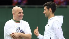 Andre Agassi a Novak Djokovič klábosí při tréninku ve Wimbledonu.