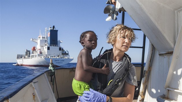 Zdravotní sestra španělské neziskové organizace Proactiva Open Arms drží dítě zachráněné ve Středozemním moři. (1. srpna 2017)