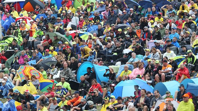 Přírodní tribuny plné lidí s deštníky. V sobotu proti slunci, v neděli proti dešti.