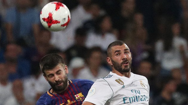 Gerrard Piqu� z Barcelony (vlevo) ve vzdu�n�m souboji s Karimem Benzemou z Realu Madrid v odvetn�m utk�n� Superpoh�ru.