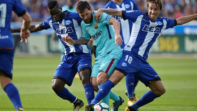 PROJDE, NEBO NE? Lionel Messi z Barcelony se probj pes dva protihre z Alavesu v utkn panlsk ligy.