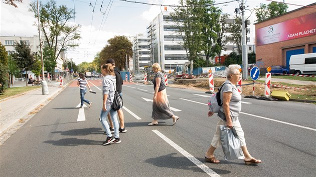 Chodci pebhaj frekventovanou tefnikovu ulici u provizorn zastvky MHD, kde chyb pechod.