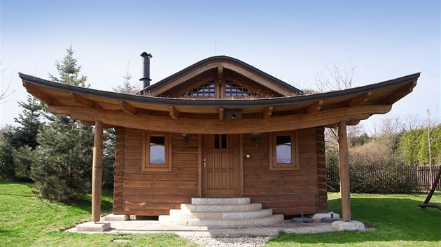 Ztvárnění zahradního srubu propojuje použití tradičních roubených trámových spojů s moderními prvky z lamelového ohýbaného dřeva.