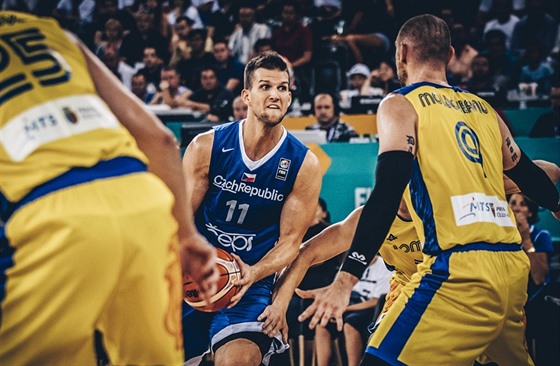 eský basketbalista Luká Palyza (v modrém) útoí na rumunský ko, brání ho...