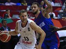 Lotyšský basketbalista Janis Strelnieks obchází Bena Mockforda z výběru Velké...