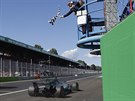 Lewis Hamilton vítzoslavn projídí cílem Velké ceny Itálie.