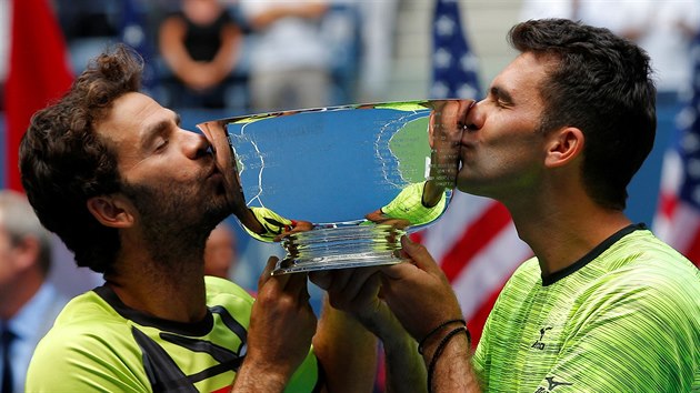 Nizozemec Jean-Julien Rojer (vlevo) a Rumun Horia Tecau líbají trofej pro šampiony mužské čtyřhry na US Open.