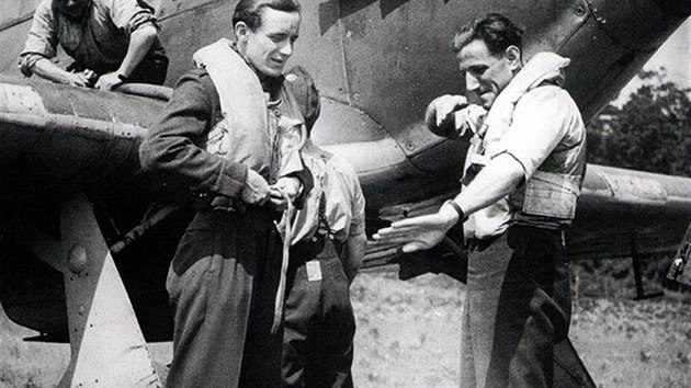 Leopold Šrom (vpravo) popisuje Františkovi Burdovi, jak šel na Němce. Za nimi je stíhačka Hawker Hurricane Mk.IIA, mezi výfuky a pilotní kabinou má nainstalovaný plech proti oslnění pilota plameny z výfuků při nočních letech. (310. peruť, červenec 1941)