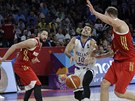 ecký basketbalista Kostas Slukas (uprosted) se prodírá mezi dvma protihrái...