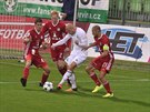 Marek Janečka z Karviné (v bílém) u míče mezi olomouckými protihráči.
