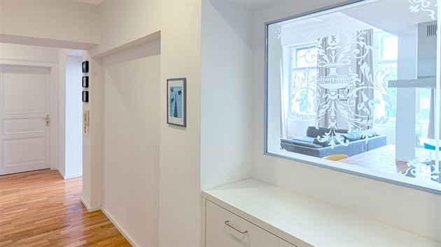 Na okénku mezi chodbou a kuchyní nechaly architektky aplikovat historizující vzor původního leptaného skla použitého v chodbách domu.