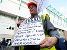 Demonstrant drí transparent kritizující pracovní podmínky zahraniních dlník...