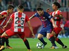 Barcelonský Lionel Messi s míčem u nohy v obležení protiháčů z Girony.