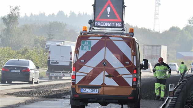 Silničáři a pracovníci specializované firmy uklízí tuny uhlí, které se v pátek ráno vysypaly z nákladního auta na dálnici D1 na Vysočině.