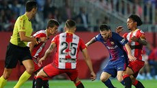 Barcelonský Lionel Messi s míem u nohy v obleení protihá z Girony.