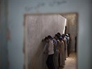 Uprchlíci z Havídi stojí pi bezpenostní kontrole ve mst Dibis u zdi, aby...