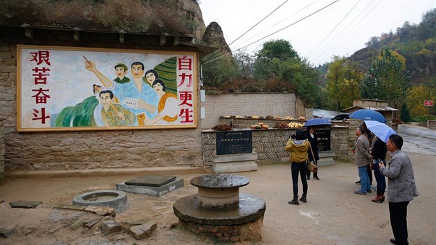 This picture taken on October 22, 2016 shows a mural extolling hard struggle outside a cave home where China's President Xi Jinping lived as a youth, in Liangjiahe, in China's Shaanxi province. Three caves in a remote Chinese village where Xi Jinping was sent during the Cultural Revolution receive a constant stream of Communist pilgrims, come to pay homage four years after he came to power.