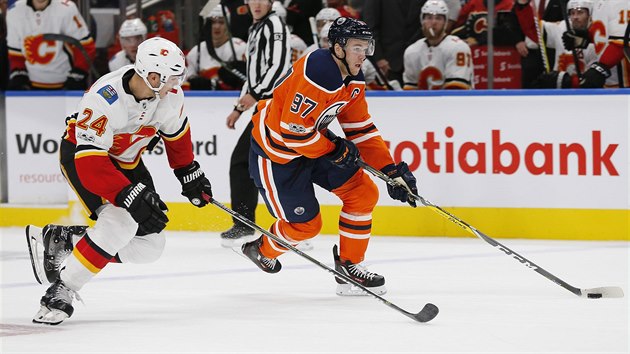 Calgarsk obrnce Travis Hamonic (v blm) se sna uastavit Connora McDavida z Edmontonu.