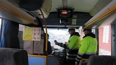 Policisté kontrolují idie autobusu.