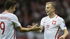 Polský útoník Robert Lewandowski (vlevo) gratuluje Kamilu Grosickému ke gólu...