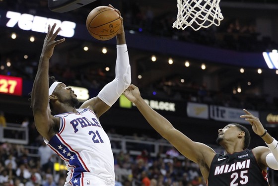 Joel Embiid (21) z Philadelphie doskoil ped Jordanem Mickeym (25) z Miami.