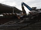 Bagr strhává hlavní tribunu fotbalového stadionu v Hradci