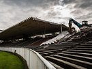 Osmaticetitunový bagr strhává hlavní tribunu fotbalového stadionu v Hradci...