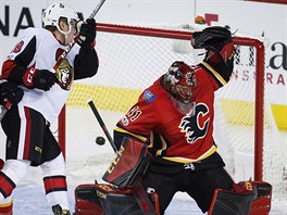 Brank Calgary Mike Smith inkasuje v utkn proti Ottaw.