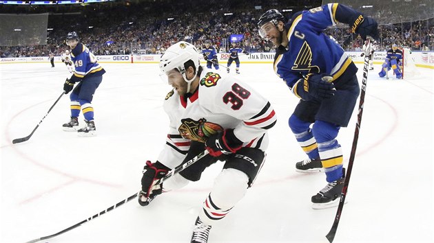 Ryan Hartman z Chicaga kontroluje puk, za zdy mu h Alex Pietrangelo ze St. Louis.