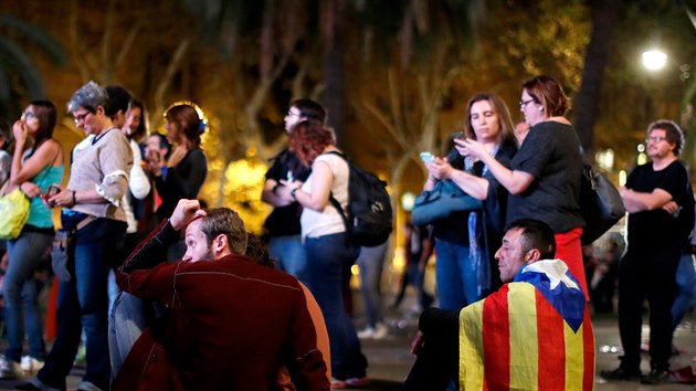 Lidé pozorují zasedání katalánského regionálního parlamentu na obrazovce na shromáždění pro nezávislost v  Barceloně (10. října 2017).