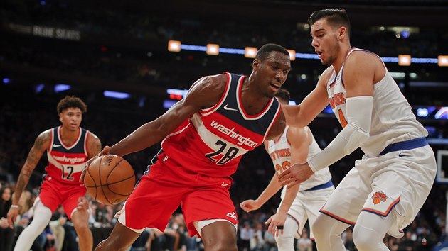 Ian Mahinmi (u me) z Washingtonu najd  kolem Willyho Hernangmeze z New Yorku.