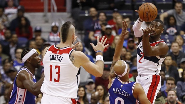 John Wall (vpravo) z Washingtonu pihrv na Marcina Gortata, brn ho Jerryd Bayless z Philadelphie.