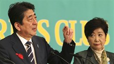 Šinzó Abe mluví, zatímco Juriko Koikeová poslouchá v průběhu předvolební...