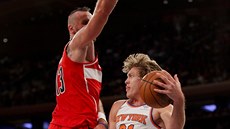 Ron Baker (vpravo) z New Yorku pihrává kolem Marcina Gortata z Washingtonu.