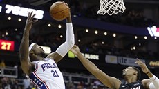 Joel Embiid (21) z Philadelphie dosko�il p�ed Jordanem Mickeym (25) z Miami.