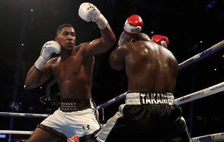 Britský boxer Anthony Joshua (vlevo) bombarduje údery kamerunského soupee...