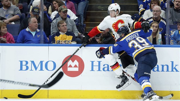 Mark Jankowski z Calgary se pokou uvolnit, brn ho Nate Prosser ze St. Louis.