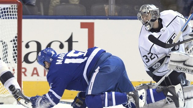 Brank Jonathan Quick z Los Angeles a tonk Matt Martin z Toronta sleduj, jak m puk do branky.