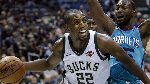 Khris Middleton z Milweukee se div, komu nahrt. Brn ho Kemba Walker z Charlotte.