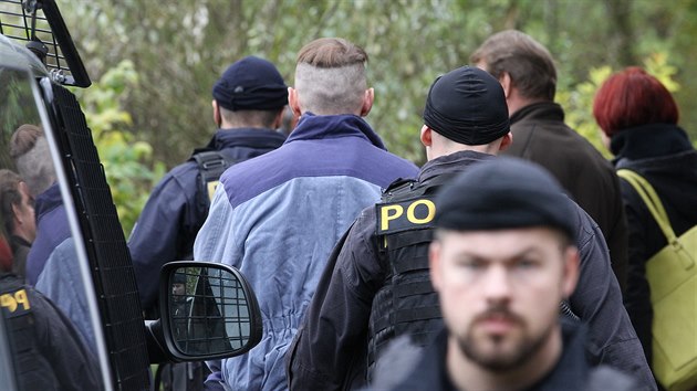 Policisté přivádějí obviněného Martina Ch. na místo činu při rekonstrukci vraždy na chalupě v Doubici.