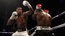 Britský boxer Anthony Joshua (vlevo) bombarduje údery kamerunského soupeře...