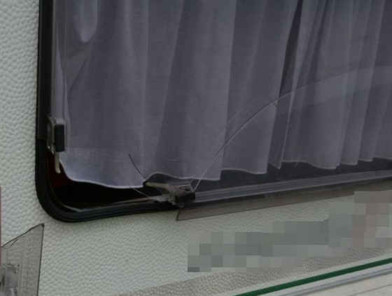 Rozbité okno, skrze které se muž vloupal v Uničově do cizího karavanu. Uvnitř...