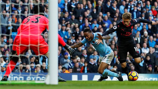 Penaltov zkrok Nacha Monreala z Arsenalu (vpravo) na Raheema Sterlinga z Manchesteru City.