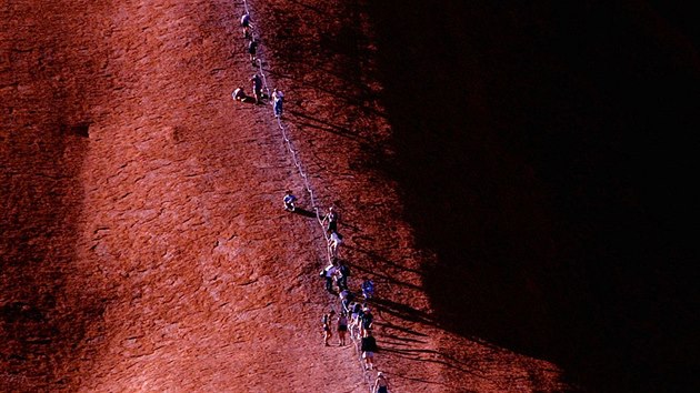 Turist plhaj na posvtnou horu Uluru v Austrlii.